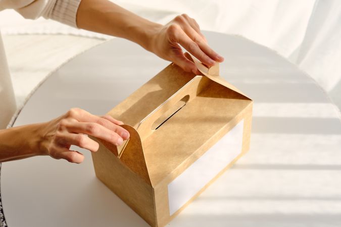 Woman unpacking box with purchase placed on table