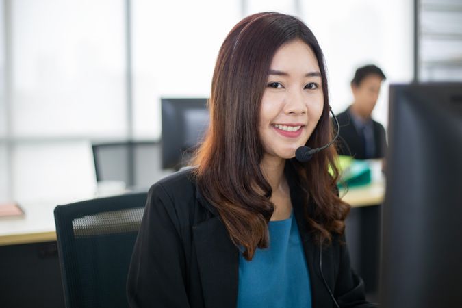 Portrait of smiling woman at work wearing headset
