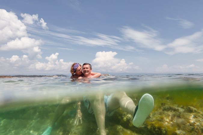 Mature couple swimming together in fresh water