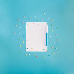 Blank paper with stars and pen on blue background