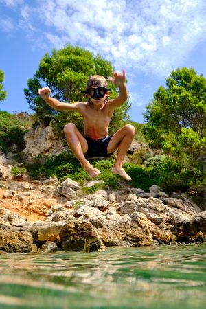 Boy in goggles jumping into water