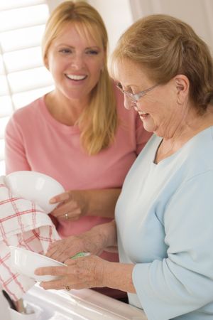 Older Adult Woman and Young Daughter Talking in Kitchen