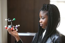 Young woman holding molecular model bDQJJ0