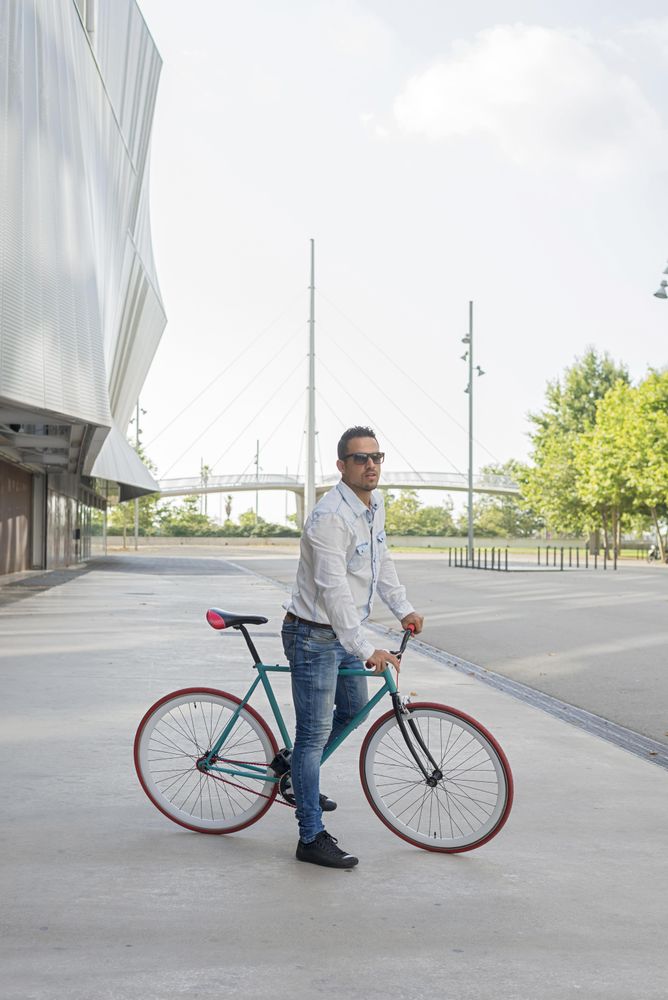 Male sitting on bike next to building