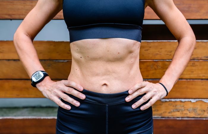 Unrecognizable sportswoman in front of a wooden background