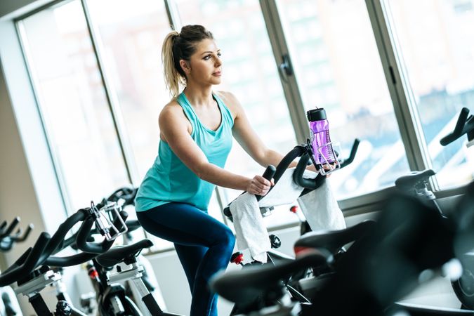 Woman with towel and water on exercise machine