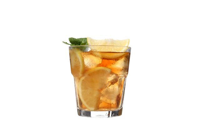 A glass of cold tea with an orange, isolated on plain background