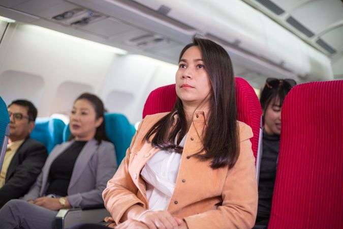Woman sitting on busy airplane