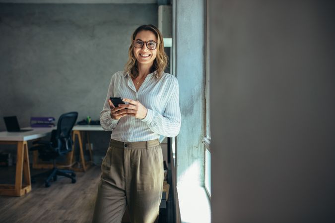 Smiling woman in casuals standing in office