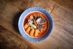 Typical hot ramen dish with fish broth in a bowl with noodles, squid, chilli, clams.
