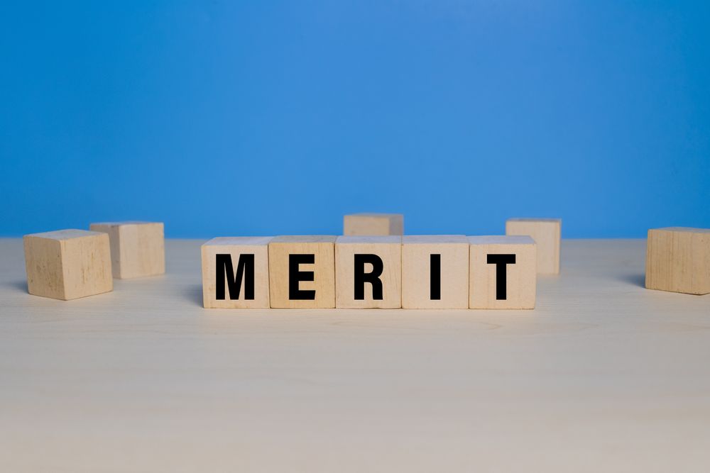 merit word text on wooden blocks isolated on blue background