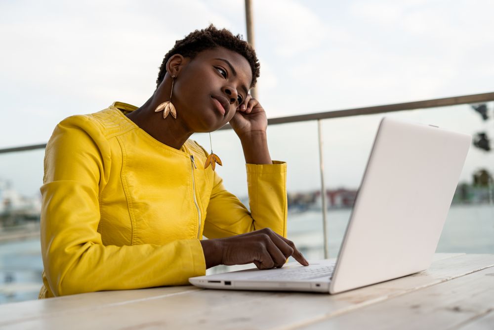 Exhausted female working on laptop at table