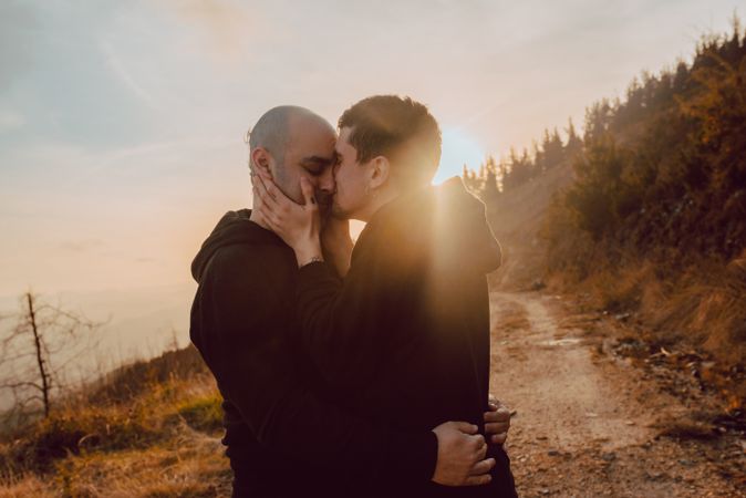 Men hugging and kissing in forest