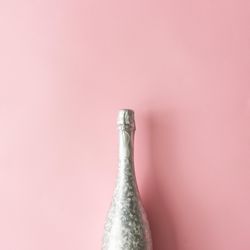 Silver Champagne bottle on pastel pink background