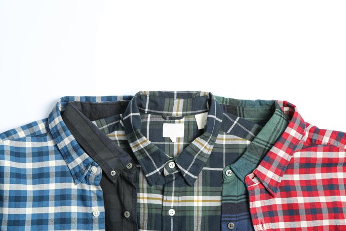 Folded colorful shirts on blank background, space for text