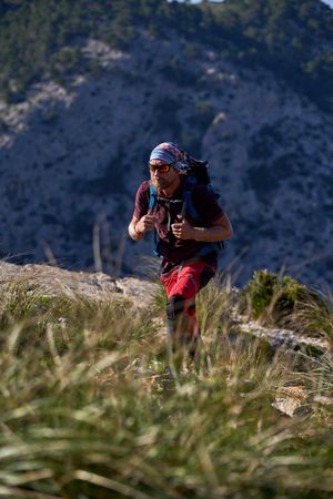Backpacker walking on slope of mountain
