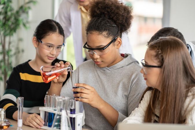 Multi-ethnic female students in science class doing chemical experiment in laboratory