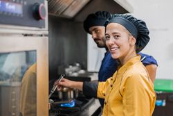 Professional chef and assistant working in kitchen