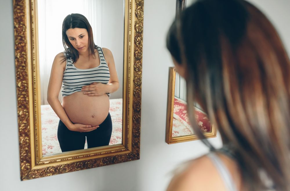 Pregnant woman looking at her belly