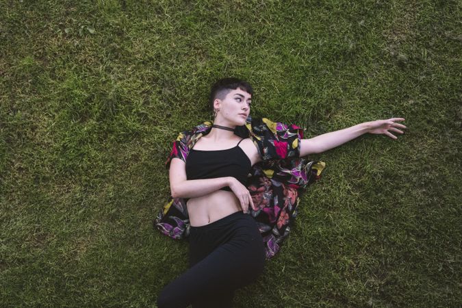 Woman in colored shirt lying on grass