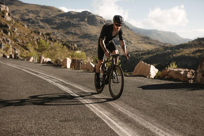 Fit athlete cycling road bike on a mountain road