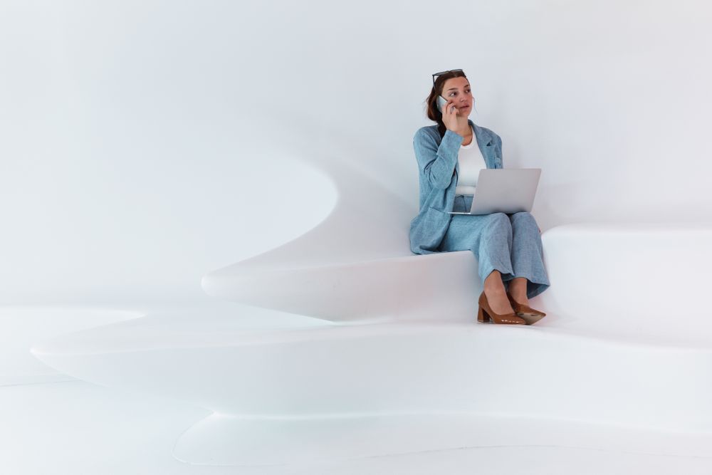 Woman with laptop talking on smartphone