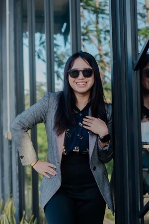 Confident young professional woman posing outdoors with a bright smile
