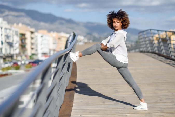 Woman stretching her legs on bridge before workout