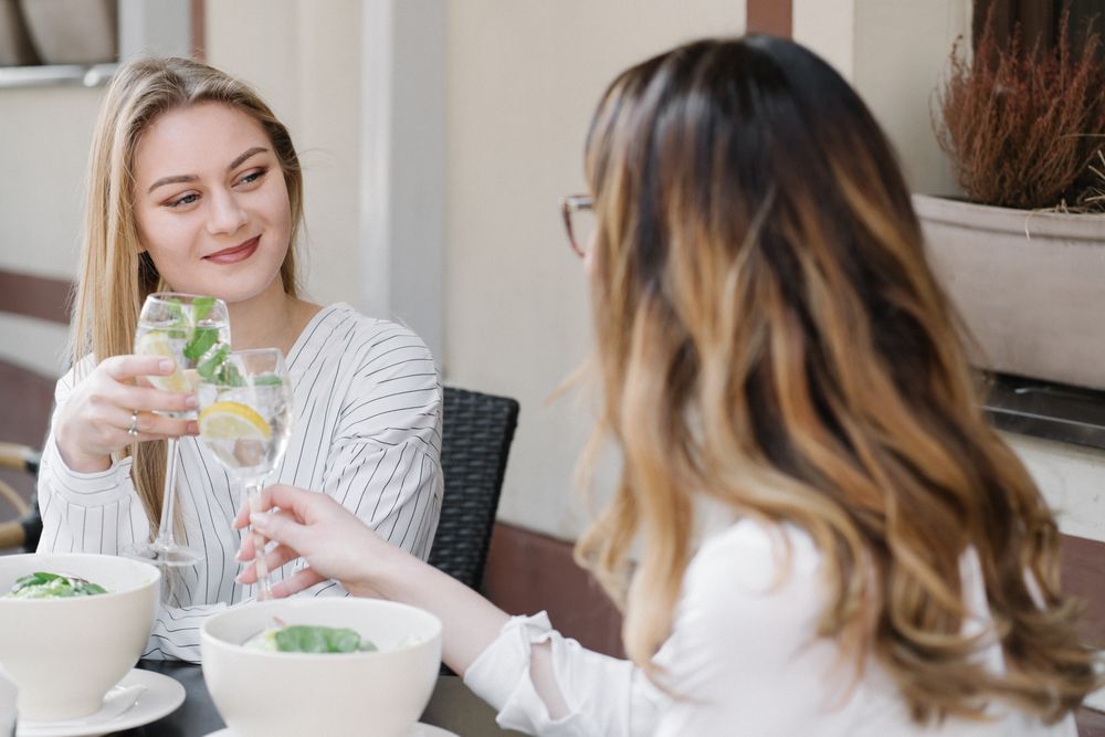 Cheerful women drinking cocktails in bar