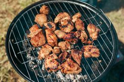 Meat is fried on a campfire, barbecue in nature. Pickled meat is cooked on coals, Grilled BBQ.
