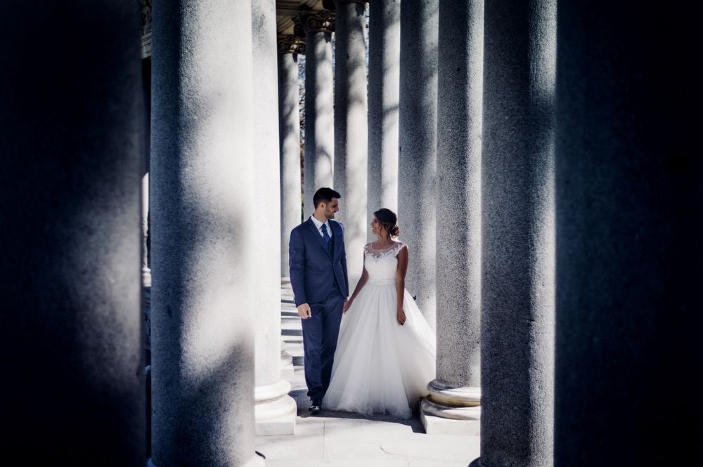 Newlyweds walking near columns