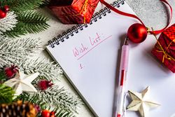 Christmas wishlist on table with pine branch