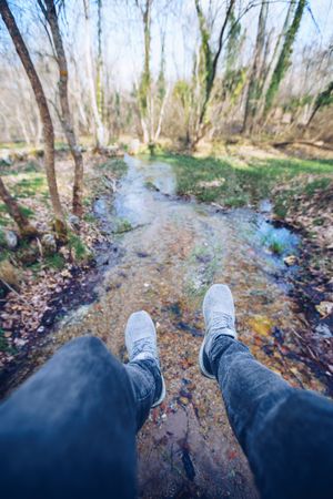 Casual man sitting on bridge in autumn forest