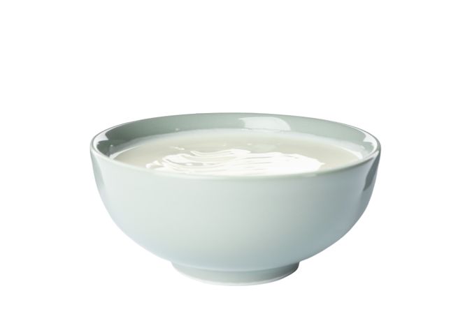 Bowl of sour cream yogurt isolated on light background