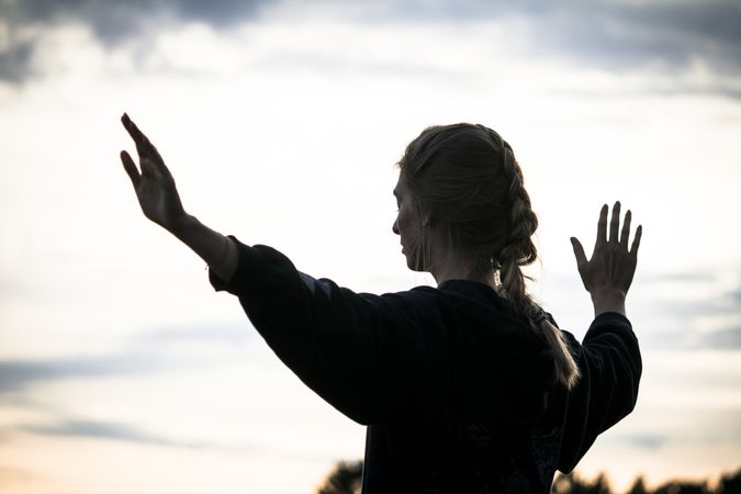 Woman meditating during sunset in nature