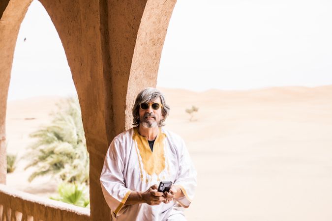 Man using phone in balcony near desert