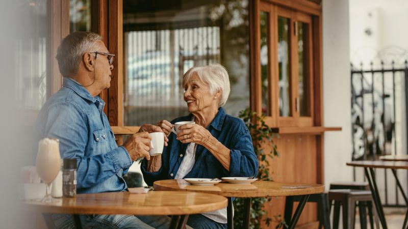Man and woman sitting at coffee shop having a conversation while having coffee
