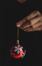 Crop person showing Christmas baubles