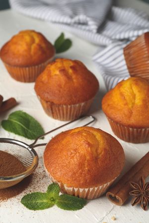 Composition with muffins and cinnamon on light background
