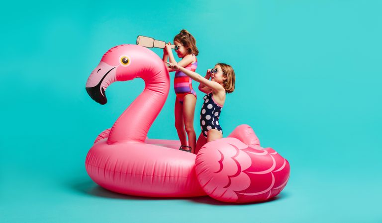 Girls in swimwear playing on inflatable mattress