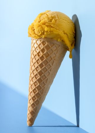 Mango ice cream in bright light, on a blue background
