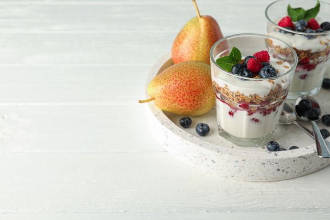 Parfaits and pears on wooden table, space for text