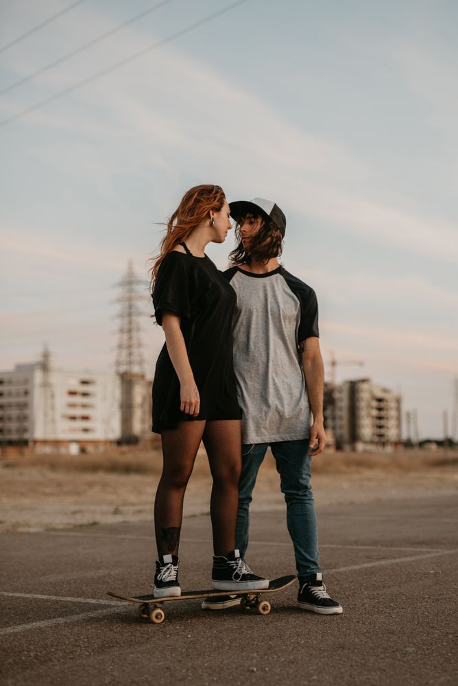 Man helping girlfriend to skate on road