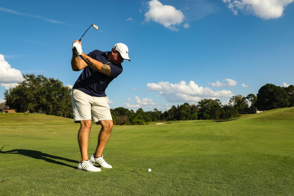 Side view of older man playing golf