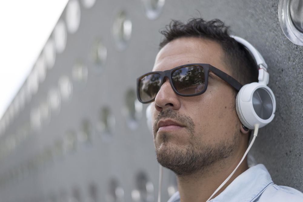 Man sitting back outside while listening to something on headphones