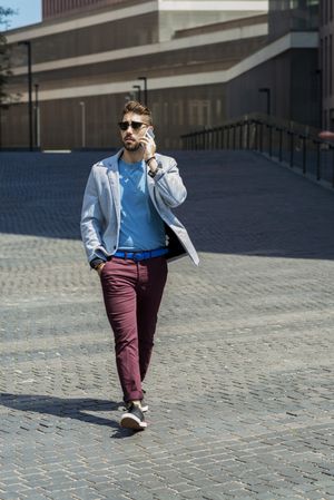 Young businessman talking on his phone while strolling outside