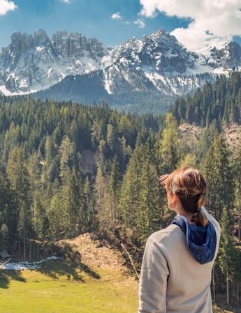 Woman covering face from sun and looking at amazing landscape
