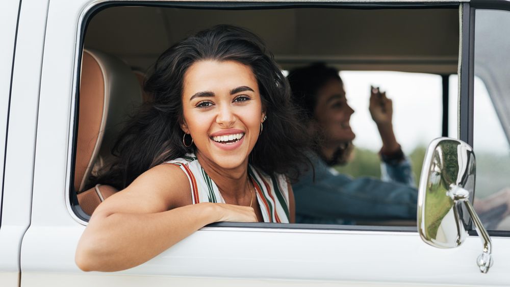 Beautiful woman smiling out from the passenger seat of a van