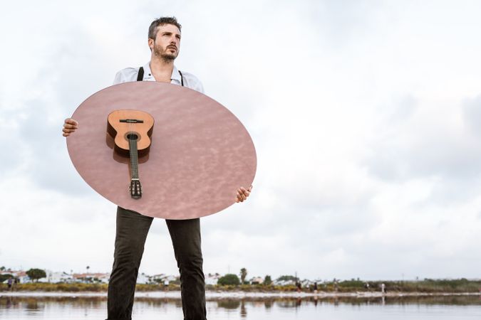Man holding mirror with guitar reflection