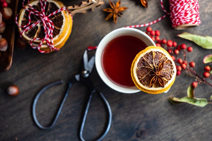 Top view close up of orange slice balancing on mug of warm tea